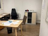 a room with a table, chairs, and a window