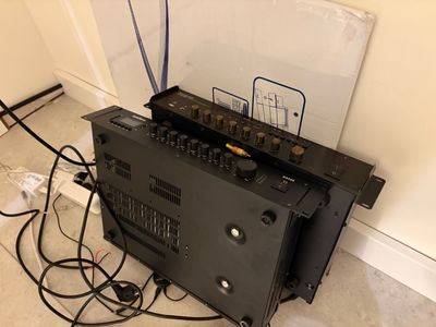 un amplificateur noir posé sur un meuble noir