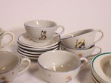 a lot of cups and saucers sitting on a table