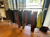 a lot of clothes hanging on a rack in a room