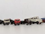 many small toy cars lined up in a row on a white surface