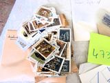 une pile de timbres posée sur une table, à côté d'un post-it