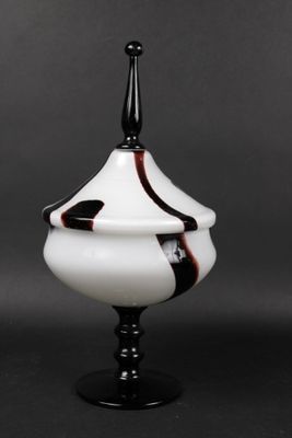 a black and white vase with a black top on a black table