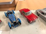 several toy cars are lined up on a table next to each other
