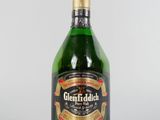 une image représentant une bouteille d'alcool vert posée sur une surface blanche