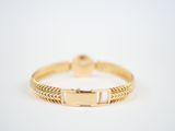 a close up of a gold bracelet on a white background