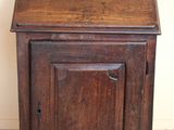 a small wooden cabinet with a door on top of it