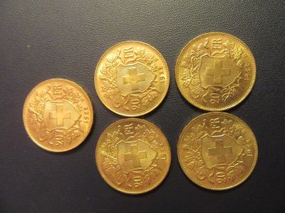 four gold coins sitting on top of each other on a table