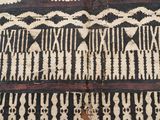 un gros plan d'un tapis noir et blanc posé sur un parquet