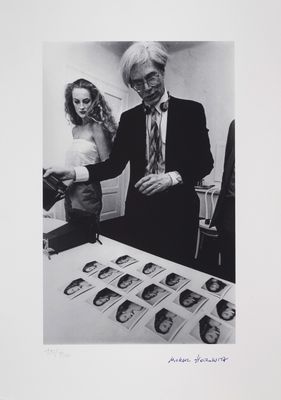 black and white photograph of a man and a woman looking at pictures
