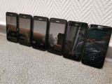 six cell phones are lined up in a row on the floor