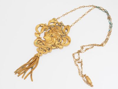 necklace with gold chain and tassel on a white background