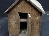 a small wooden dog house with a door open