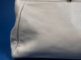 a close up of a white purse on a blue background