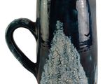 a black and blue coffee mug with a tree design on it