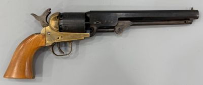 un gros plan d'un revolver accroché au mur, avec une crosse en bois