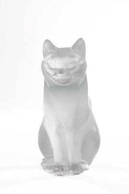 a white cat figurine sitting on a white surface