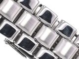 a close up of a metal bracelet on a white surface