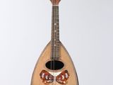 a guitar hanging from a string on a white wall