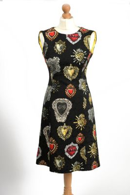 the dress is black with gold and red hearts on it