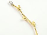 La broche en forme de fleur, en or et diamants, est représentée sur un fond blanc
