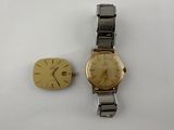 an image of a gold watch and a silver watch on a white surface