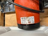 a red bucket sitting on top of a white box
