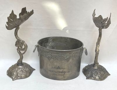 a silver bucket sitting next to two candles on a table