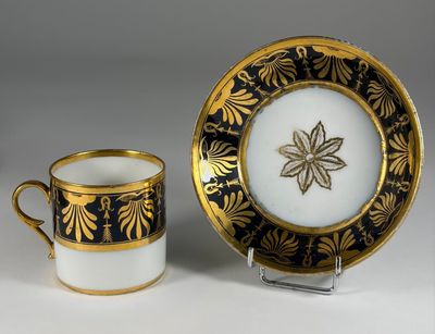 a black and gold cup and saucer
