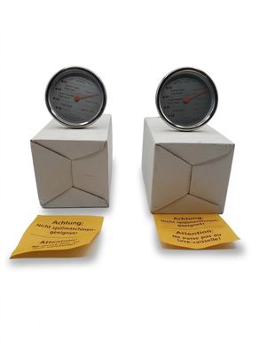deux boîtes flanquées de thermomètres de chaque côté, posées sur une surface blanche