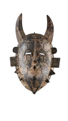 une image représentant un masque en bois muni de cornes sur fond blanc