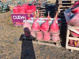 un homme debout devant une pile de bouteilles de gaz