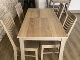 a wooden table and chairs in a room with a brick wall
