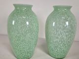 two green vases sitting next to each other on a table