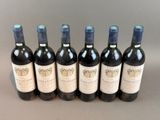 six bottles of wine are lined up in a row on a table