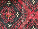 close up of a red and black rug with a pattern on it
