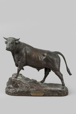 statue of a bull standing on a rock on a gray background