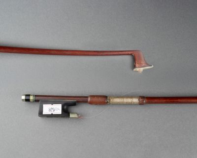 un gros plan sur un archet de violon et un repose-archet posés sur une table