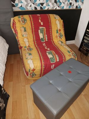 a futon chair and ottoman in the corner of a bedroom