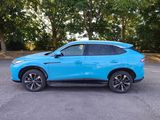 a blue suv parked in a parking lot with trees in the background