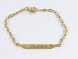 un gros plan sur un bracelet en or sur lequel est gravé un prénom