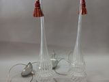 une paire de lampes en verre transparent avec des abat-jours rouges sur fond blanc