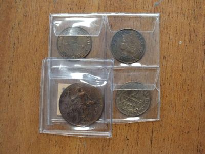 four different types of coins in plastic bags sitting on a table