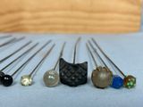 five pins of different colors and sizes on a table