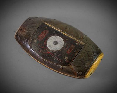 Un vieux téléphone portable est posé sur une table sur laquelle se trouve une horloge.