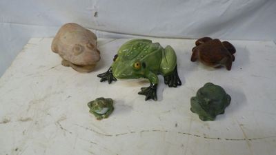 plusieurs figurines de grenouilles et un crâne sur un fond blanc