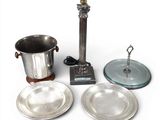 une assiette en argent, ainsi qu'une tasse et une soucoupe en argent, posées sur une table