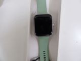 a green apple watch sitting in a white box