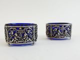 pair of silver and blue glass bowls on a white surface