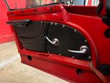a close up of a red car door with a black handle